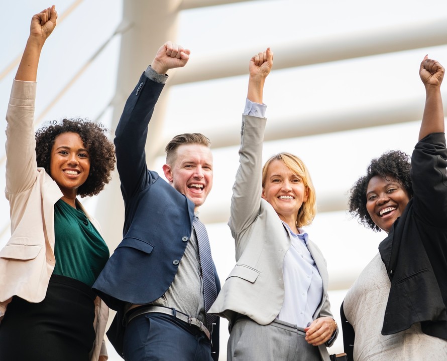 Four colleagues celebrating with raised fists