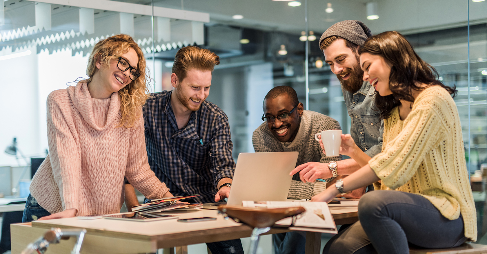 A team gathered around a laptop, sharing ideas